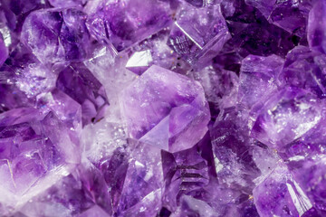 Amethyst purple crystals. Gems. Mineral crystals in the natural environment. Texture of precious and semiprecious stones. Seamless background with copy space colored shiny surface of precious stones.