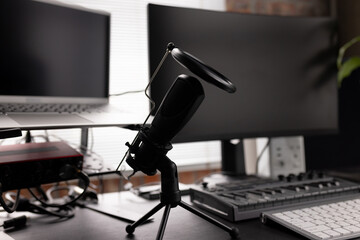 Podcasting set up with computers, keyboard and microphone on desk at home