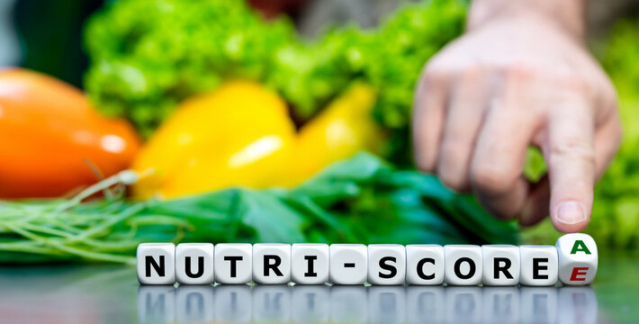 Hand turns dice and changes the Nutri-score from E to A. Symbol for a healthier life.
