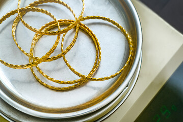 Stack of  24k (24 carat) Turkish gold twist bracelet on precision jeweler's scale