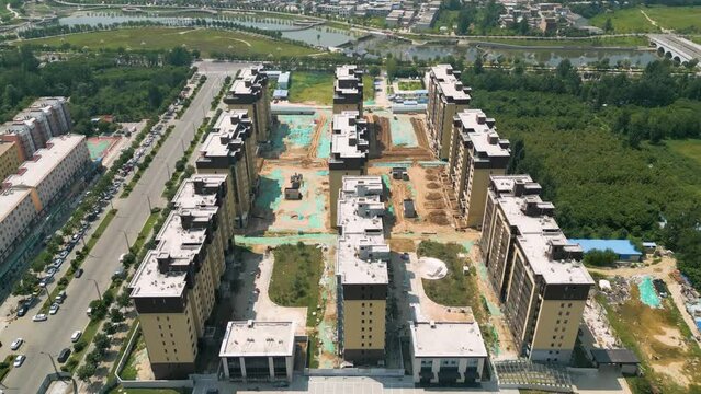 Aerial over construction site with apartments, ever-evolving urban landscape in Huayin, a city nestled in the heart of Shaanxi Province, China. City's rapid development and growth concept. UHD.