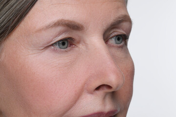 Senior woman with aging skin on white background, closeup. Rejuvenation treatment