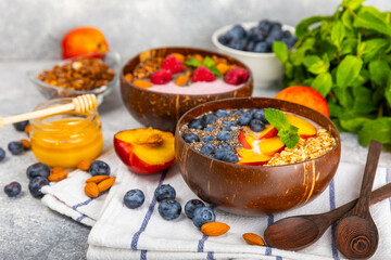Granola bowl. Yogurt with oatmeal, fresh berries, spirulina and chia seeds. Healthly food. Tasty breakfast. Yogurt with strawberries, raspberries, blueberries, peaches, mint and mendal. Copy space.