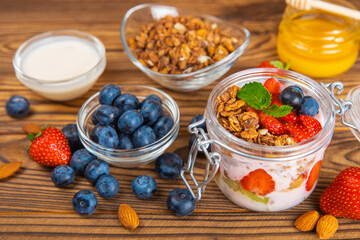 Granola bowl. Yogurt with oatmeal, fresh berries, spirulina and chia seeds. Healthly food. Tasty breakfast. Yogurt with strawberries, raspberries, blueberries, peaches, mint and mendal. Copy space.