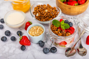 Granola bowl. Yogurt with oatmeal, fresh berries, spirulina and chia seeds. Healthly food. Tasty breakfast. Yogurt with strawberries, raspberries, blueberries, peaches, mint and mendal. Copy space.