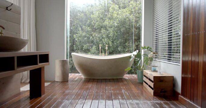 General view of bathroom with bathtub and window, slow motion