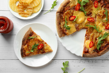 Delicious Hawaiian pizza with pineapple and ingredients on white wooden table, flat lay