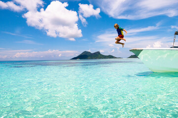 Child jumping into sea water. Yacht vacation.