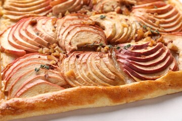 Freshly baked apple pie with nuts on white table, closeup