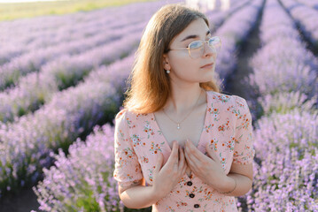 A young woman with glasses in the morning in a lavender field