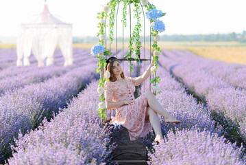 A woman sitting in a metal chair in the middle of a lavender field