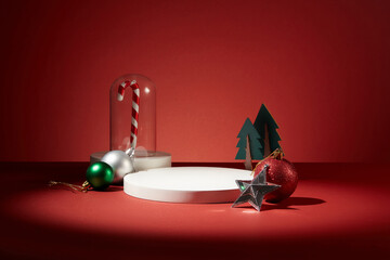 A candy cane inside a glass cage displayed with few sparkling baubles, a star and christmas trees....