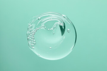 Sample of cleansing gel on turquoise background, top view. Cosmetic product