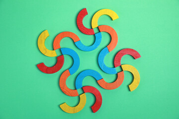 Colorful wooden pieces of play set on green background, flat lay. Educational toy for motor skills...