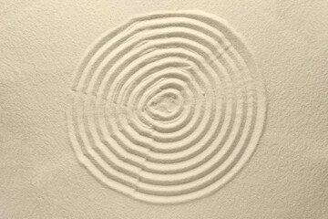 Fototapeta na wymiar Beautiful spiral on sand, top view. Zen garden