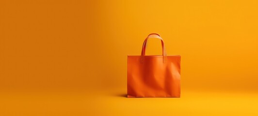 Stylish empty orange shopping bag against a vibrant yellow background, perfect for retail, consumerism, and fashion concepts