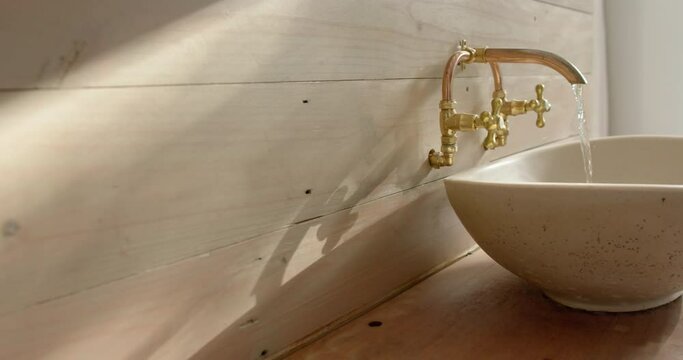 Close up of washbasin with running water in bathroom, slow motion