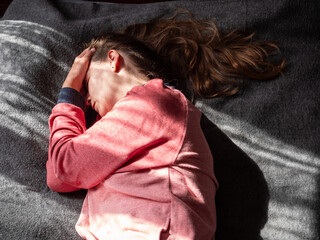 Stressed tired exhausted millennial woman on bed eyes closed suffers from headache Mental health...