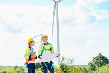 Technician engineer caucasian worker builders looking for wind turbine blueprint drawings for wind turbine construction at windmill field farm. Alternative renewable energy for clean energy concept.