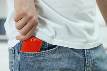 Man pulling condom out of pocket, closeup
