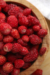 Fresh wild strawberries in bowl on table, top view