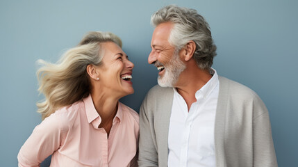 Beautiful gorgeous 50s mid age elderly senior model couple with grey hair laughing and smiling. Mature old man and woman close up portrait.