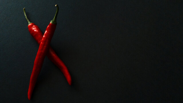 Red hot natural chili pepper on a dark background. Chili tenderloin path. Organic fresh chili pepper isolated on black.