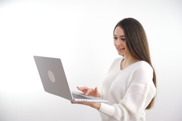 Naklejka premium Pointing laptop screen, portrait of caucasian 20s woman pointing laptop screen. Woman holding modern laptop with empty blank screen mockup for website. Smiling happy girl. Isolated white background.