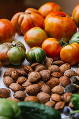 Harvesting of vegetables and nuts from the orchard. Selective approach. Red tomatoes, green tomatoes, cucumber, peppers and almonds. Concept of harvest, orchard and sustainability