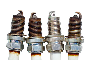 Old spark plugs isolated on white background. Spark plugs with worn electrodes. Used, burned four...