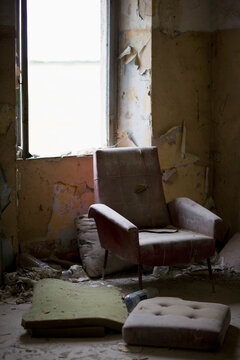 Dusty armchair in dirty and empty room
