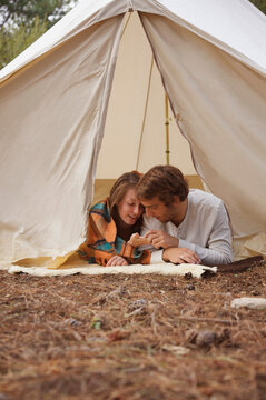 Young couple lying in a tent entrance
