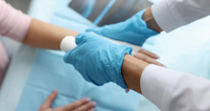 Traumatologist bandages patient sore arm. Hand injuries and sprains concept