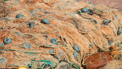 Close-up of tangled fishing net and buoys  on the quayside