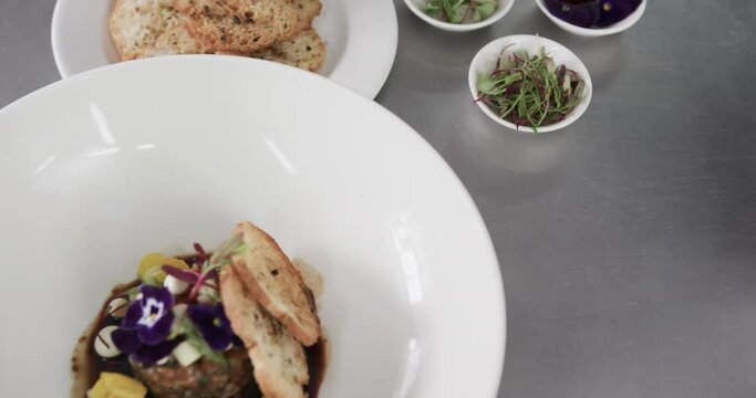 Prepared and decorated meal on white plate in kitchen, slow motion