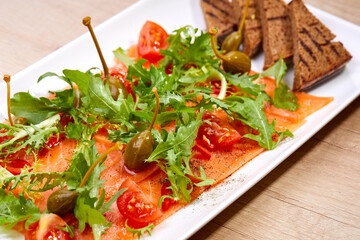 salmon carpaccio with capers and bread