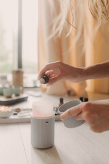 Air humidifier, calm blurred woman, girl practice meditation do yoga exercise at home. Aromatherapy...