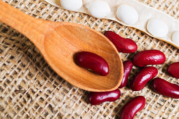 Row dry red beans in wooden scoop on burlap, ingridient for recipe nourishing legume cuisine