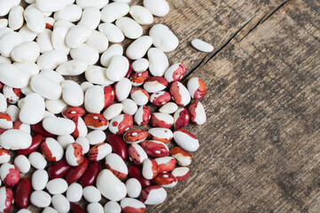 Raw white and red organic beans lie on a burlap sack on the table. Healthy legume food