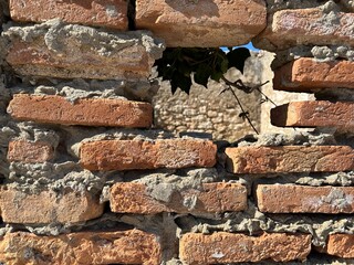 Ruins of an old fortress, a hole in the stone. Hole in the ancient fortress wall. Brick structure...