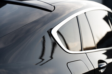 Close up of prestigious modern vehicle with tinted windows, chrome details and black surface....