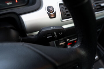 Naklejka premium Black leather steering wheel with shift level and dashboard of well designed car according to new technologies. Parts of interior in modern auto.