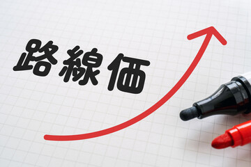 路線価と上向きの矢印が書かれたノートとマーカー