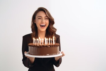 A woman holding a chocolate cake with lit candles. Perfect for birthday celebrations and special occasions.
