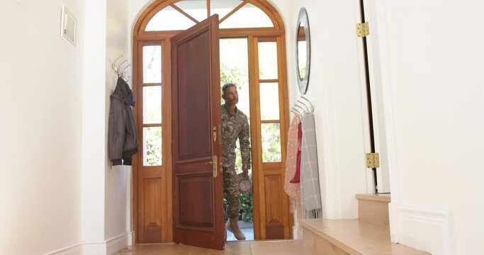 Caucasian male soldier in uniform returning home walking into house