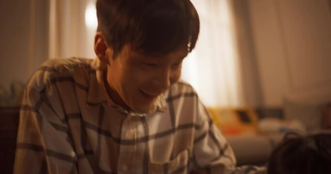 아들이 공책에 그린 그림을 꼼꼼히 살펴보며 칭찬하는 엄마와 아빠