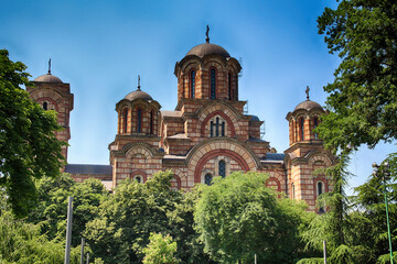 Fototapeta na wymiar St. Mark's Church exterior view with green trees in sunny bright summer day
