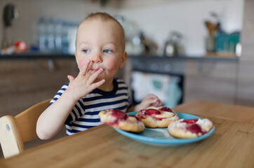 the child eats dessert and licks his fingers