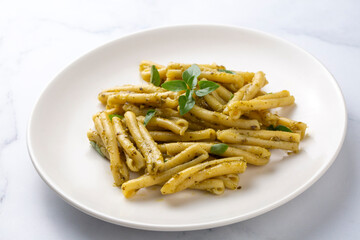 Casarecce pasta with cilantro pesto sauce on a grey background, top view. Delicious vegetarian lunch.