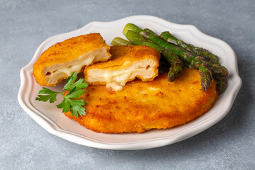 Cordon bleu served with asparagus.